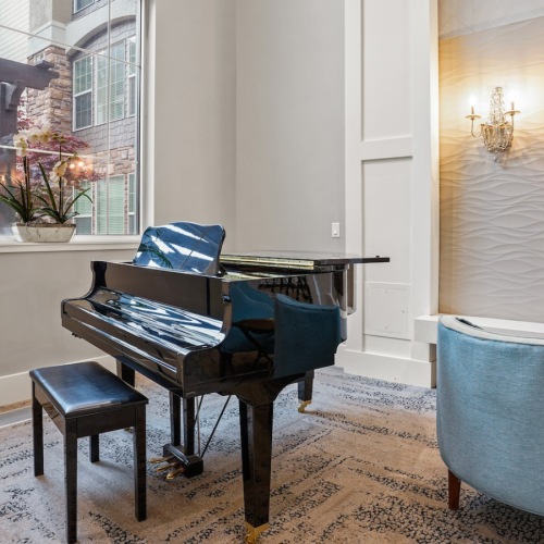 State-of-the-art amenities Resident lounge at The Ivy at Draper 55 and over Apartments in Draper, UT, featuring a grand piano and natural lighting.